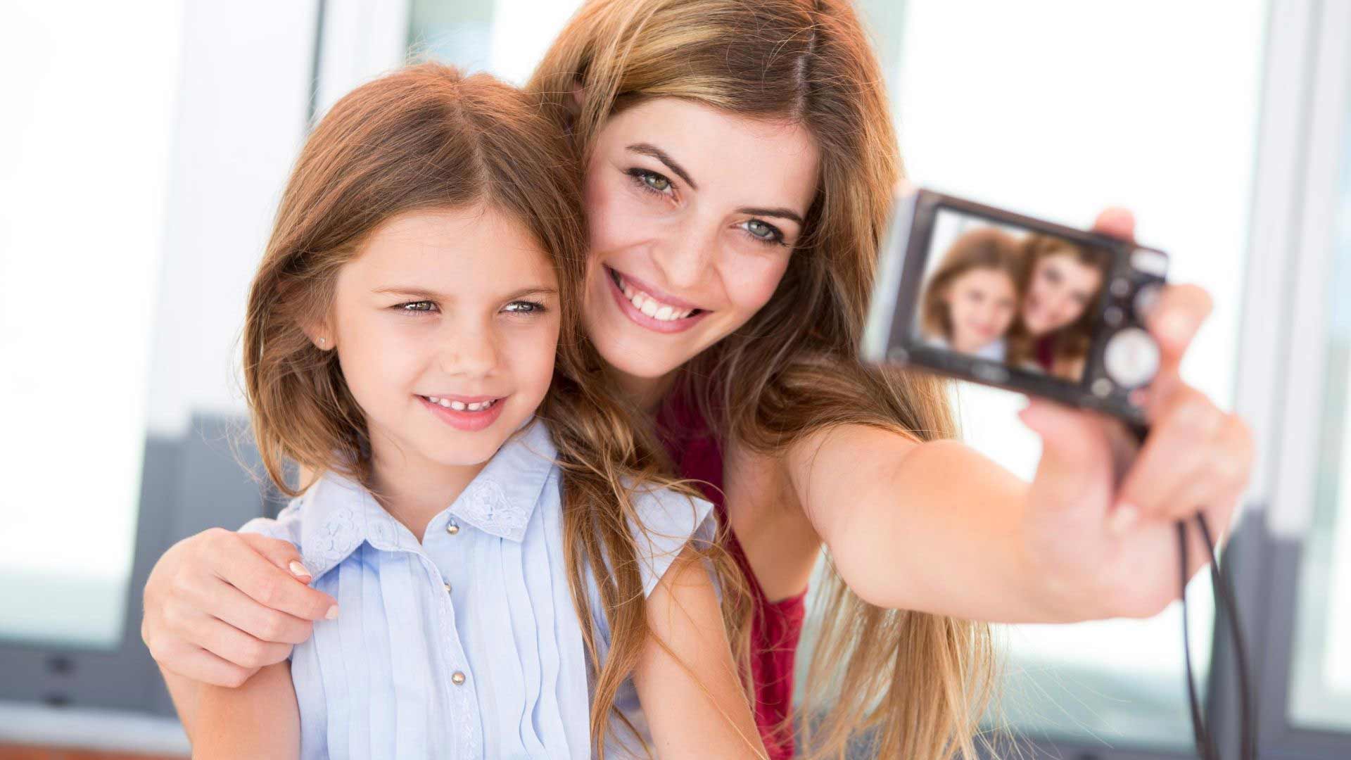 mother and daughter trying to take the perfect selfie